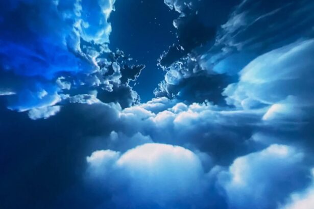 Blue sky with scattered white clouds and a deep blue gradient, resembling a view through an opening in the clouds with a few stars.