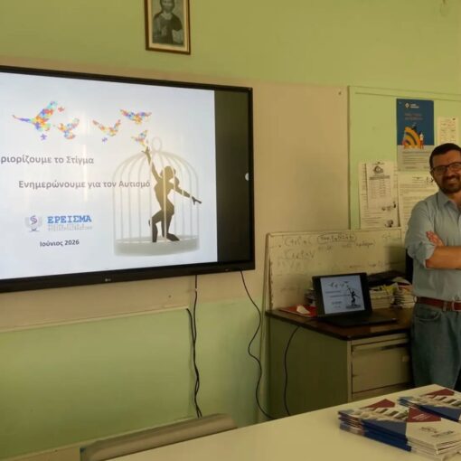 Presenter in a classroom giving a talk about reducing stigma and autism awareness (June 2026) with a large screen showing butterflies and a cage image.